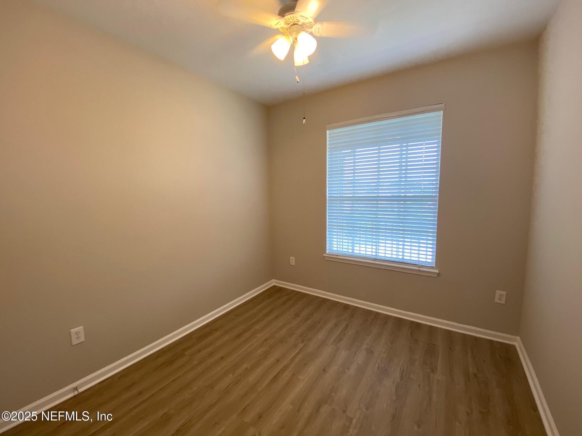 7990 Baymeadows Road, Unit 929 Jacksonville, FL 32256 - Photo 13 of 26 a view of an empty room with wooden floor and a window