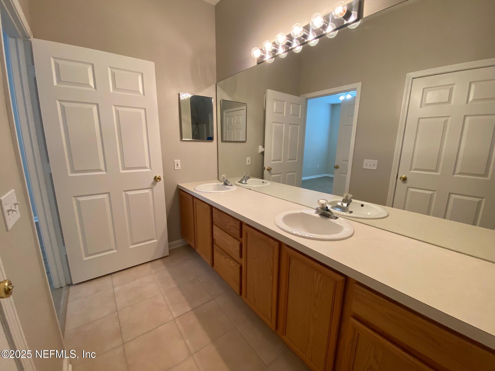 7990 Baymeadows Road, Unit 929 Jacksonville, FL 32256 - Photo 14 of 26 a bathroom with a double vanity sink and a mirror