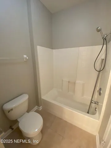 a white toilet sitting next to a bath tub and a shower