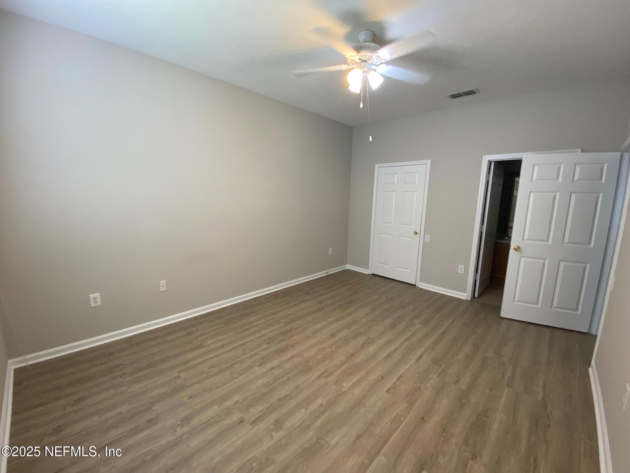 7990 Baymeadows Road, Unit 929 Jacksonville, FL 32256 - Photo 17 of 26 an empty room with wooden floor and ceiling fan
