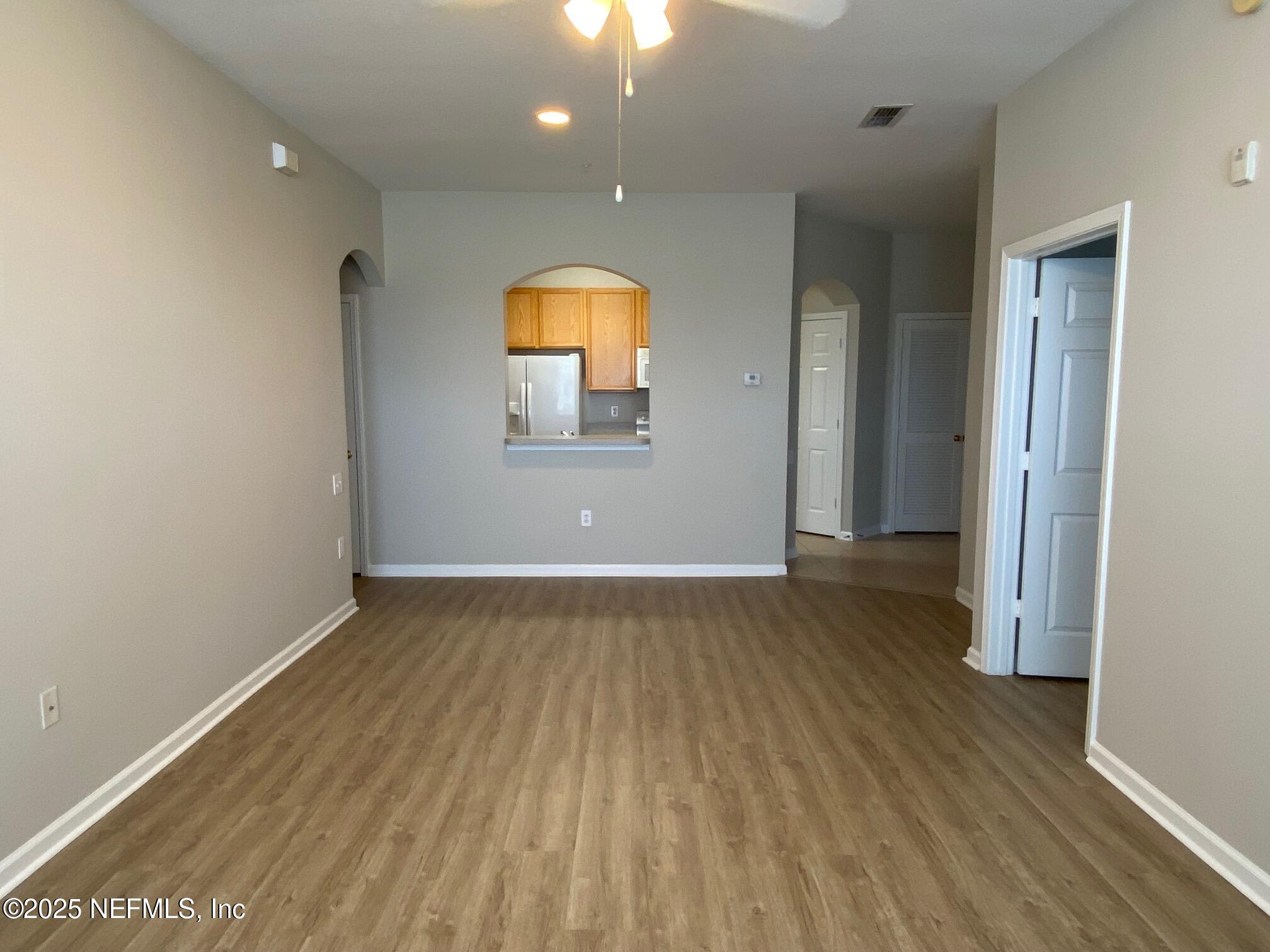 7990 Baymeadows Road, Unit 929 Jacksonville, FL 32256 - Photo 5 of 26 an empty room with wooden floor and mirror