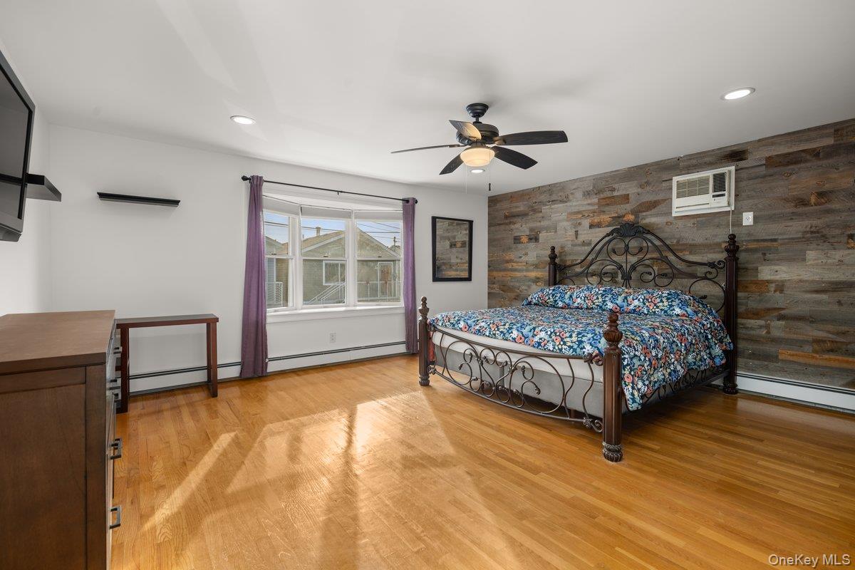 19 West 13th Road Queens, NY 11693 - Photo 4 of 19 a bedroom with a bed windows and wooden floor