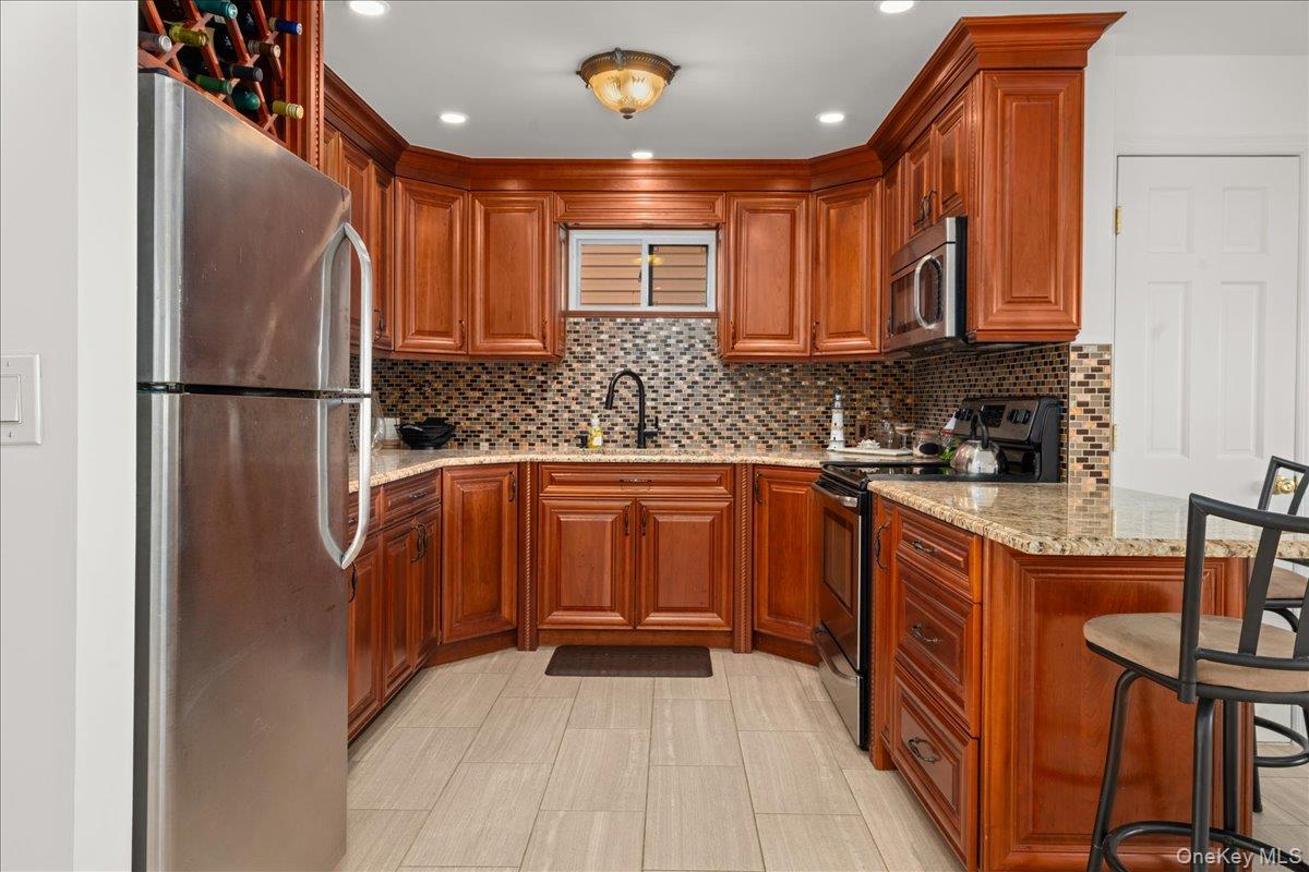 19 West 13th Road Queens, NY 11693 - Photo 6 of 19 a kitchen with stainless steel appliances granite countertop a refrigerator a sink dishwasher a stove with wooden cabinets and floor