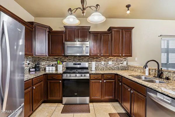 a kitchen with stainless steel appliances granite countertop a refrigerator stove and microwave