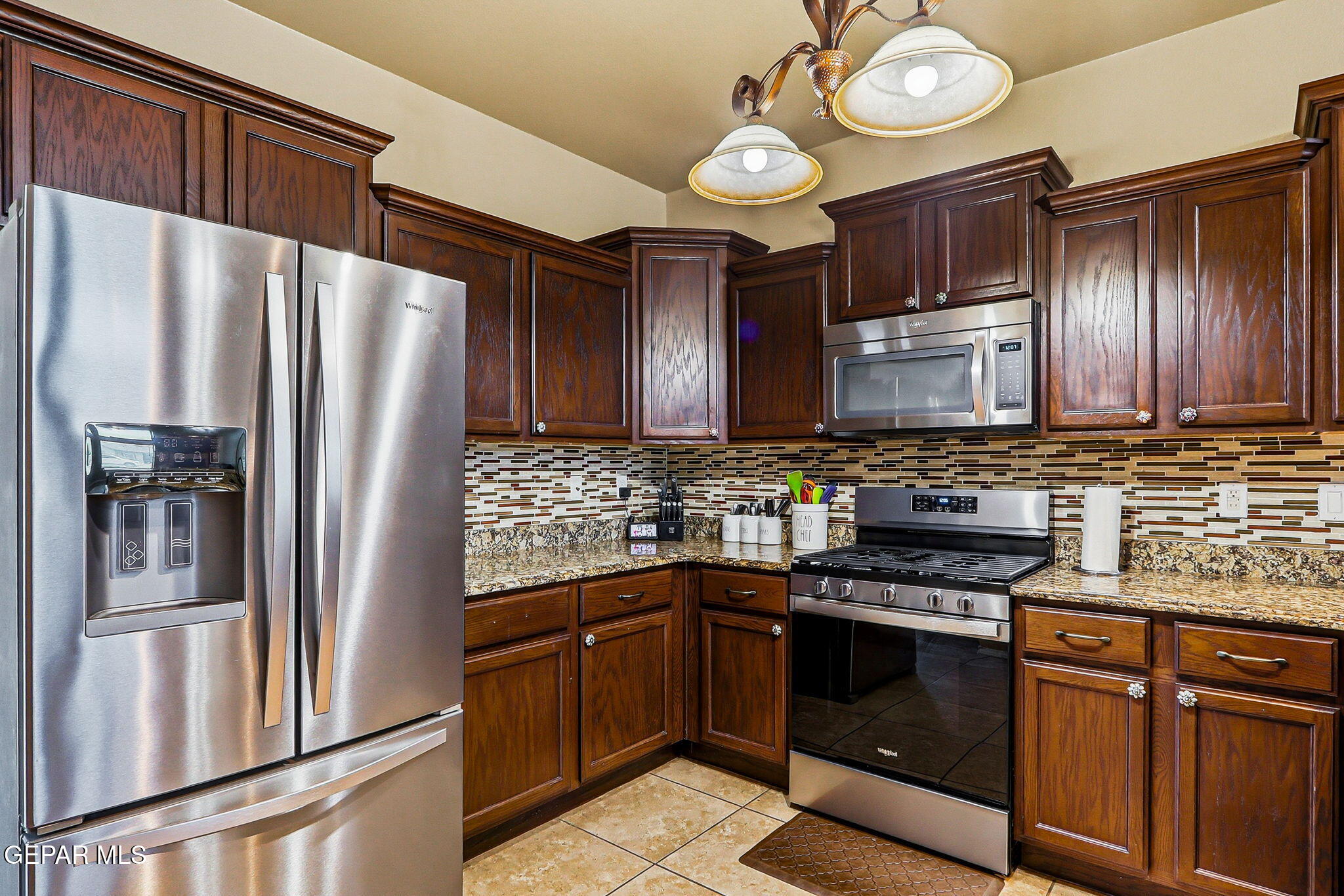 612 Bell Gordon Street Anthony, TX 79821 - Photo 15 of 64 a kitchen with stainless steel appliances granite countertop a refrigerator stove and microwave