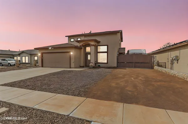 a front view of a house with a big yard and garage