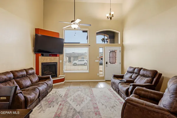 a living room with furniture a fireplace and a flat screen tv