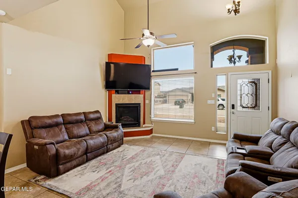 a living room with furniture a flat screen tv and a fireplace