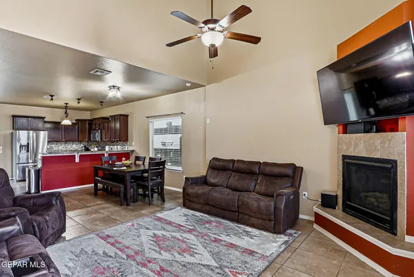 a living room with furniture a flat screen tv and a fireplace