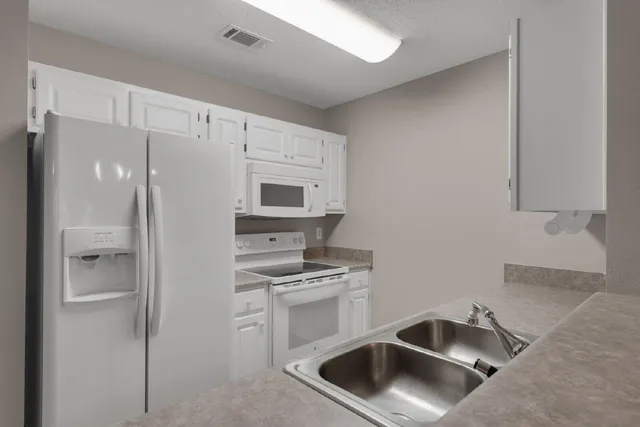 a kitchen with white cabinets and stainless steel appliances