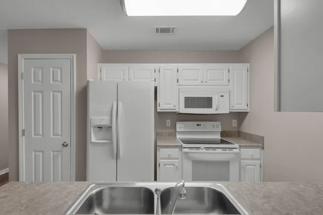 a kitchen with stainless steel appliances a refrigerator stove and sink