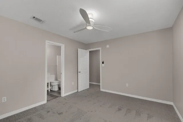 an empty room with a ceiling fan and a window