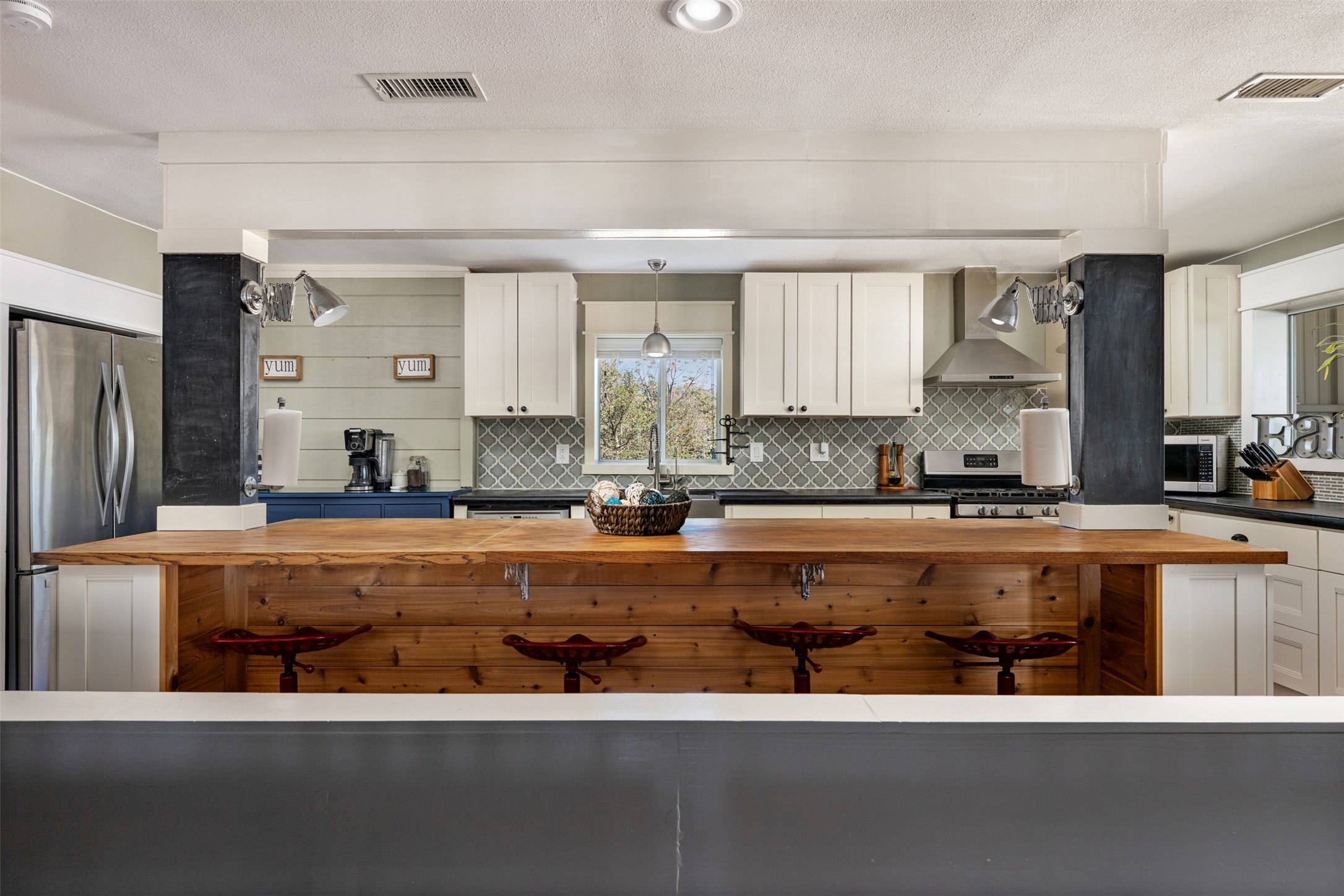 6501 County Road 239 Jarrell, TX 76537 - Photo 7 of 40 Kitchen featuring white cabinetry, wood and concrete counters, stainless steel appliances, and decorative backsplash