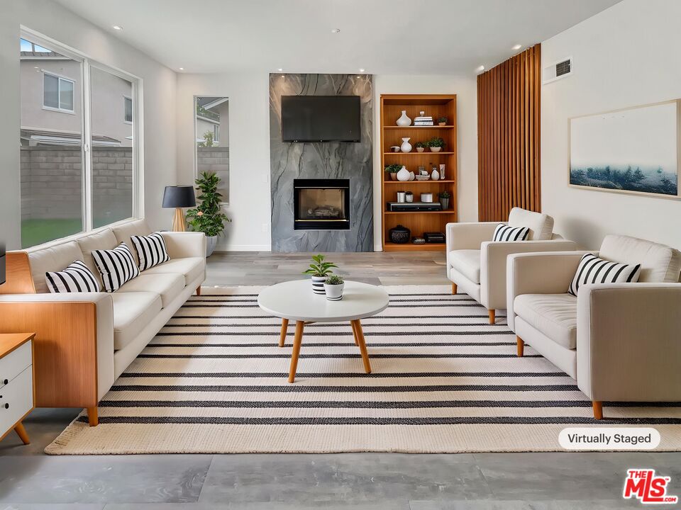 125 Lakeside Drive Buena Park, CA 90621 - Photo 2 of 57 a living room with furniture a fireplace and a large window