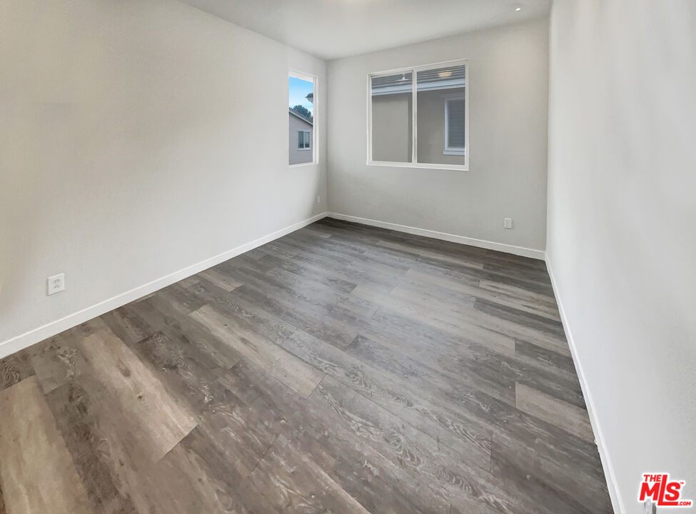 125 Lakeside Drive Buena Park, CA 90621 - Photo 21 of 57 a view of an empty room with wooden floor and a window