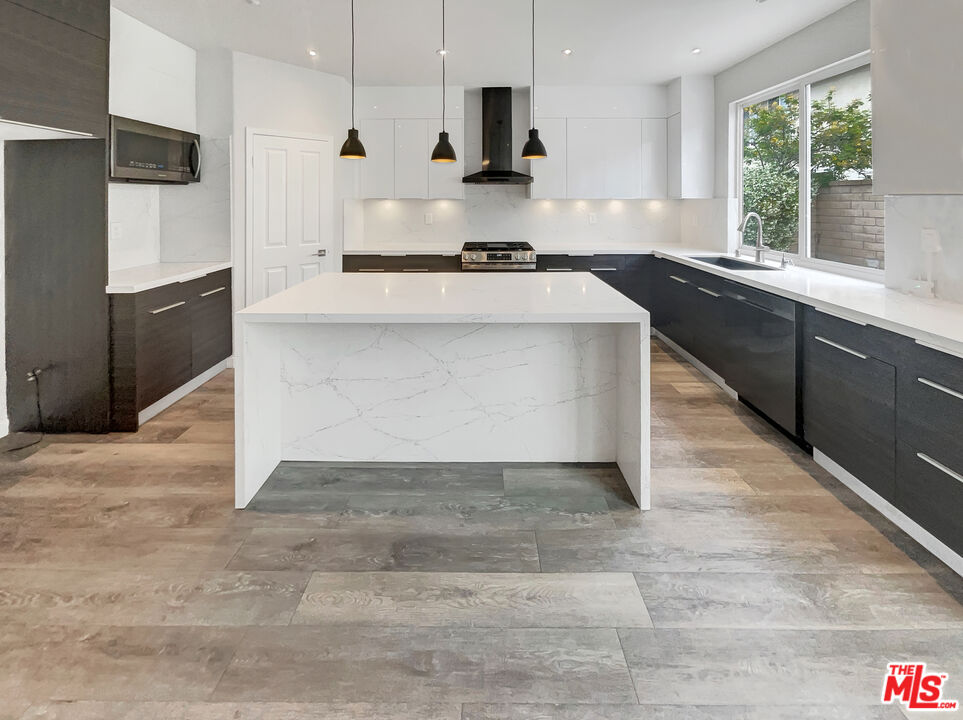 125 Lakeside Drive Buena Park, CA 90621 - Photo 28 of 57 a large kitchen with granite countertop a stove a sink a refrigerator and a granite counter top