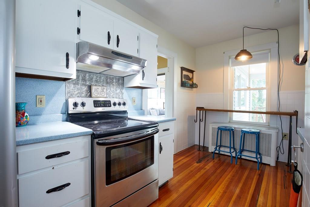 202 Metropolitan Avenue Boston, MA 02131 - Photo 6 of 31 a kitchen with stainless steel appliances granite countertop a stove and a wooden floors