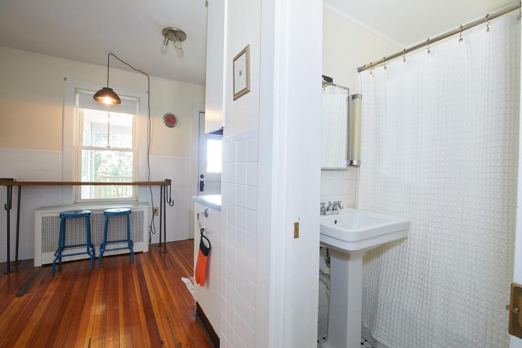 202 Metropolitan Avenue Boston, MA 02131 - Photo 10 of 31 a bathroom with a sink a mirror and shower