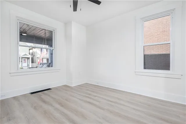 a view of a hallway with wooden floor and entryway