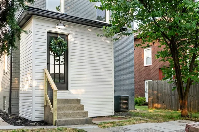 a view of a house with a yard and a tree