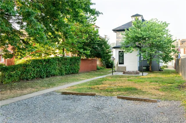 a view of a backyard with table and chairs plants and trees