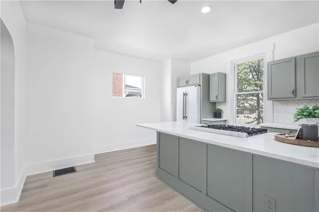 a kitchen with a stove and a wooden floor