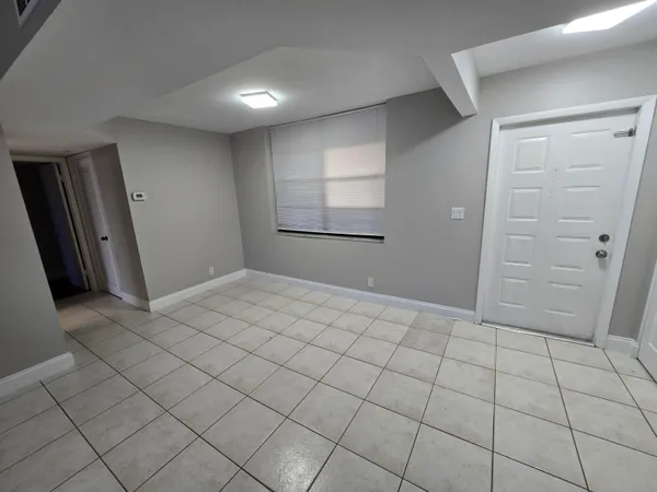 a view of an empty room with wooden floor and closet