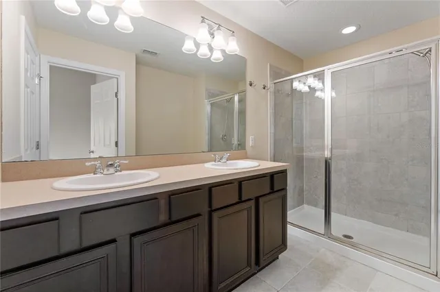 a bathroom with a double vanity sink mirror and shower