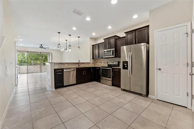 a kitchen with stainless steel appliances granite countertop a refrigerator and a sink