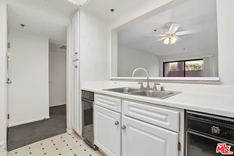 a kitchen with granite countertop a sink stove and cabinets