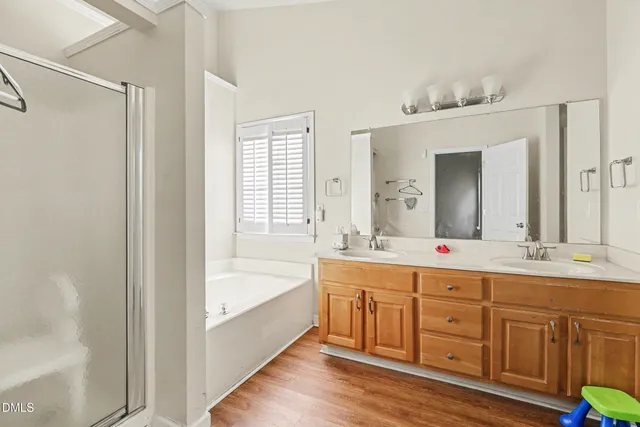 a spacious bathroom with a double vanity sink tub double and mirror