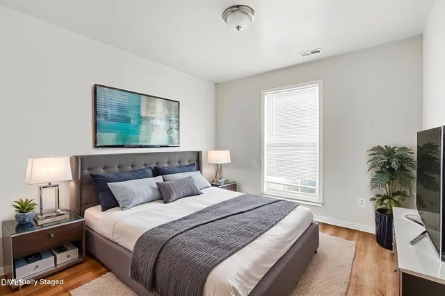 a bedroom with a bed and a potted plant