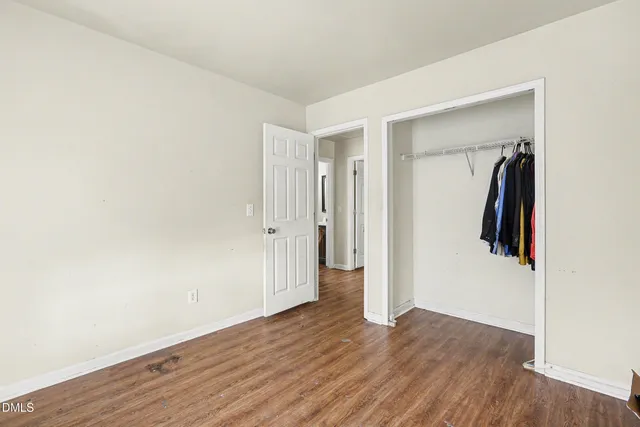 an empty room with wooden floor and closet