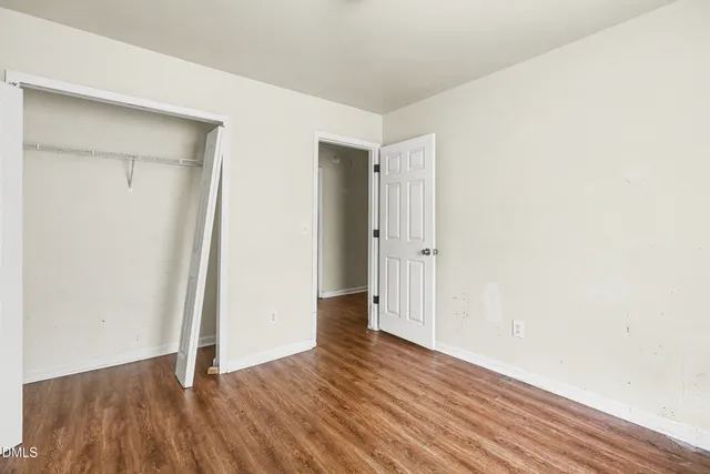 a view of an empty room with wooden floor