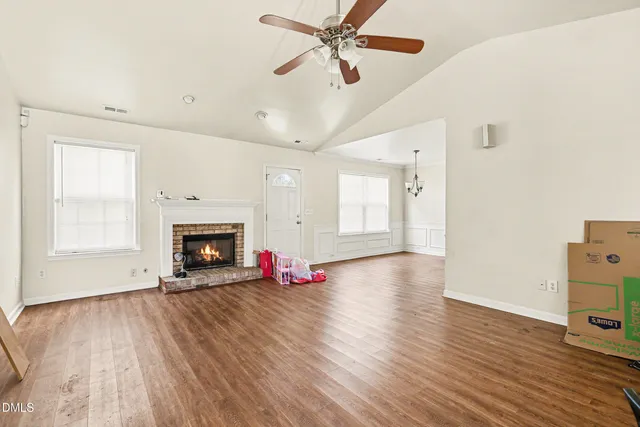 a view of an empty room with window and wooden floor