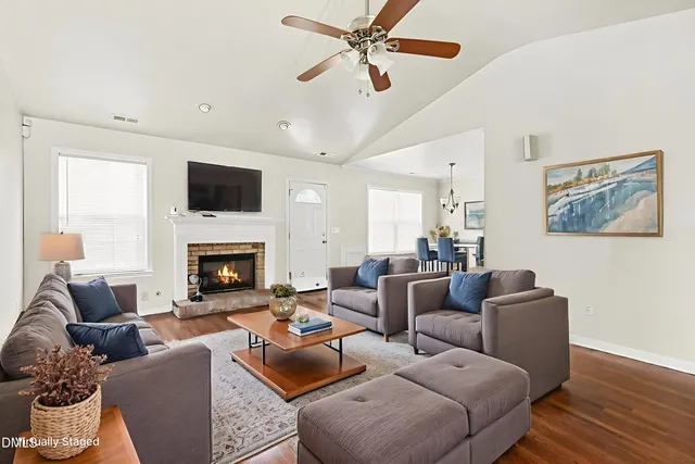 a living room with furniture a fireplace and a flat screen tv