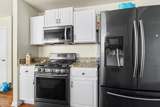 a kitchen with stainless steel appliances a refrigerator stove and microwave