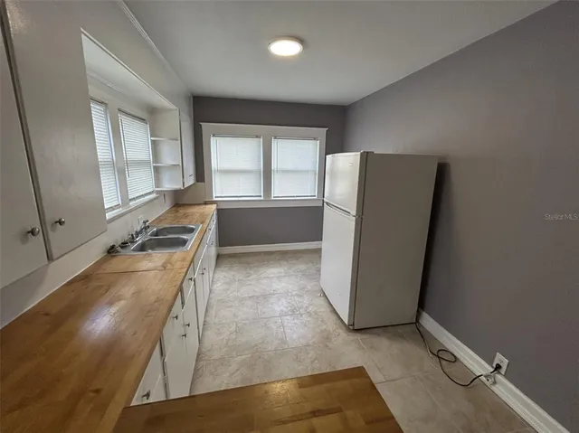 a view of a kitchen with a sink and dishwasher a refrigerator with wooden floor