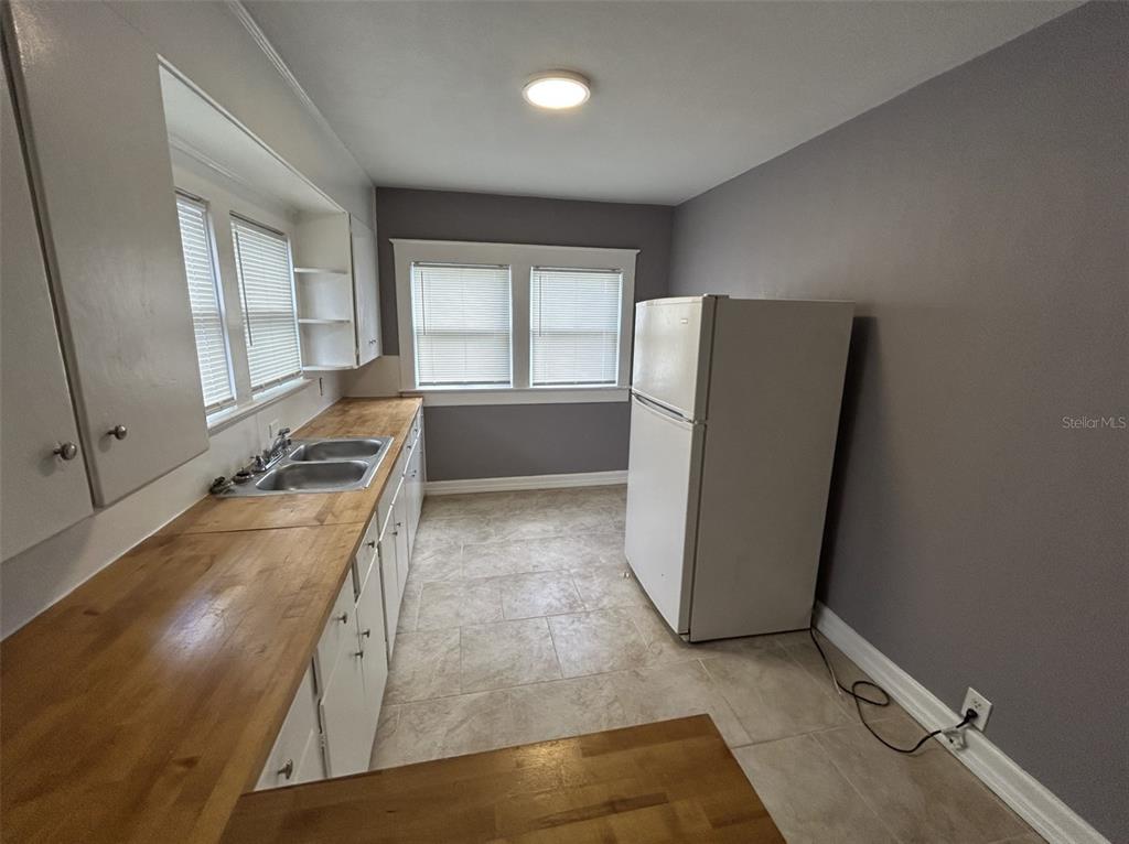 620 5th Avenue West, Unit A DOWNSTAIRS Palmetto, FL 34221 - Photo 3 of 13 a view of a kitchen with a sink and dishwasher a refrigerator with wooden floor