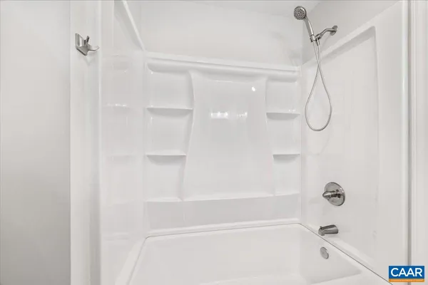 a bathroom with a bath tub with a shower