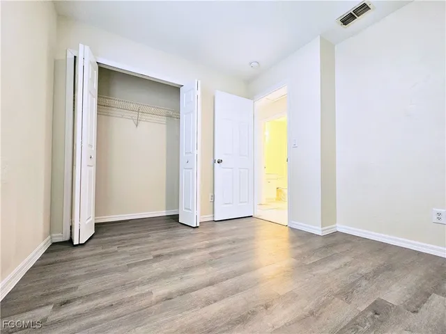 an empty room with wooden floor and closet
