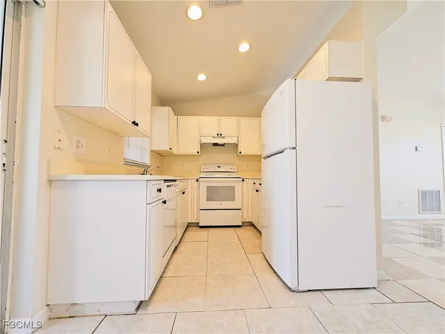 a kitchen with white cabinets and white appliances
