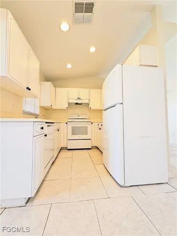 a kitchen with white cabinets and white appliances