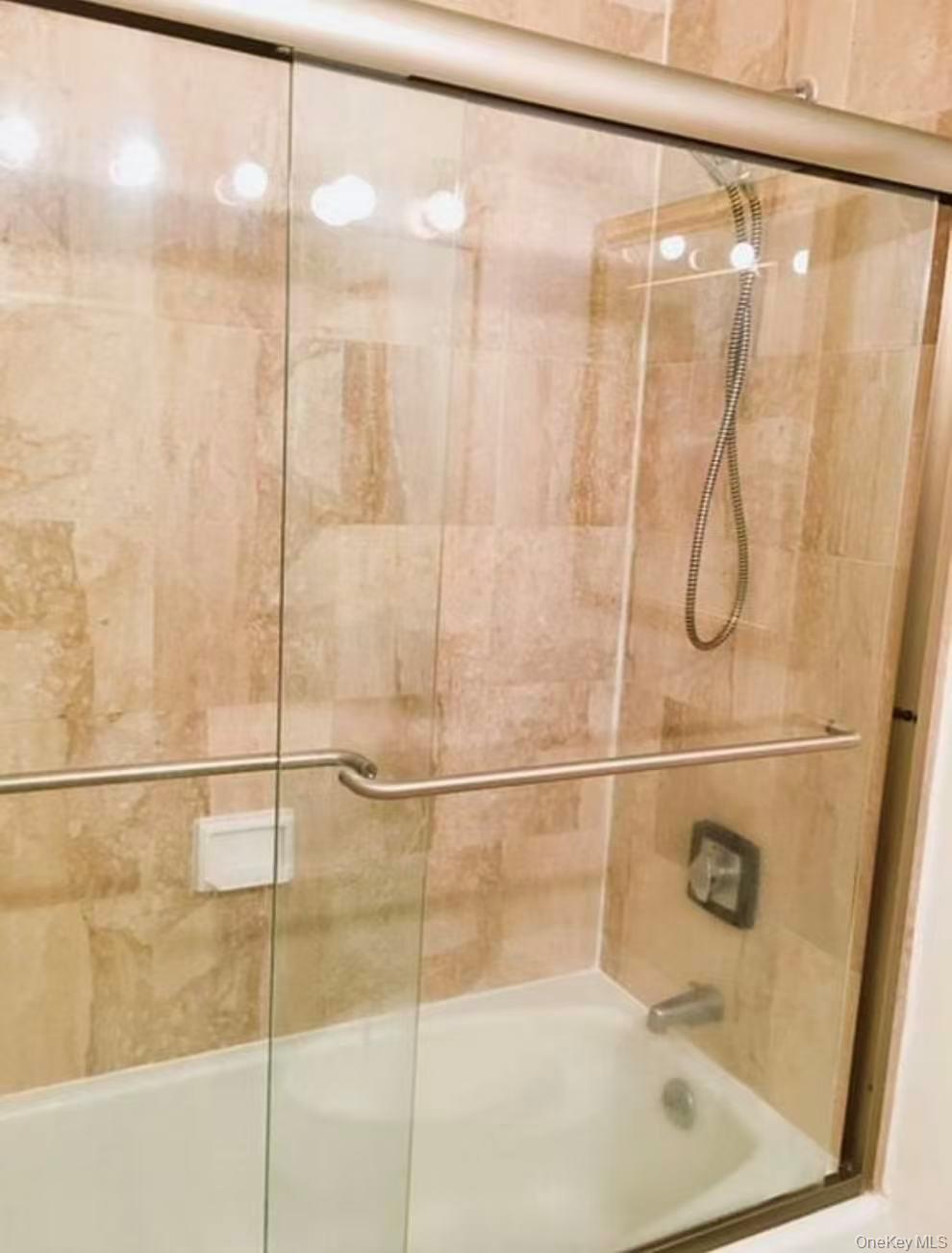 145 East 48th Street, Unit 22C Manhattan, NY 10017 - Photo 4 of 11 a bathroom with a glass shower door