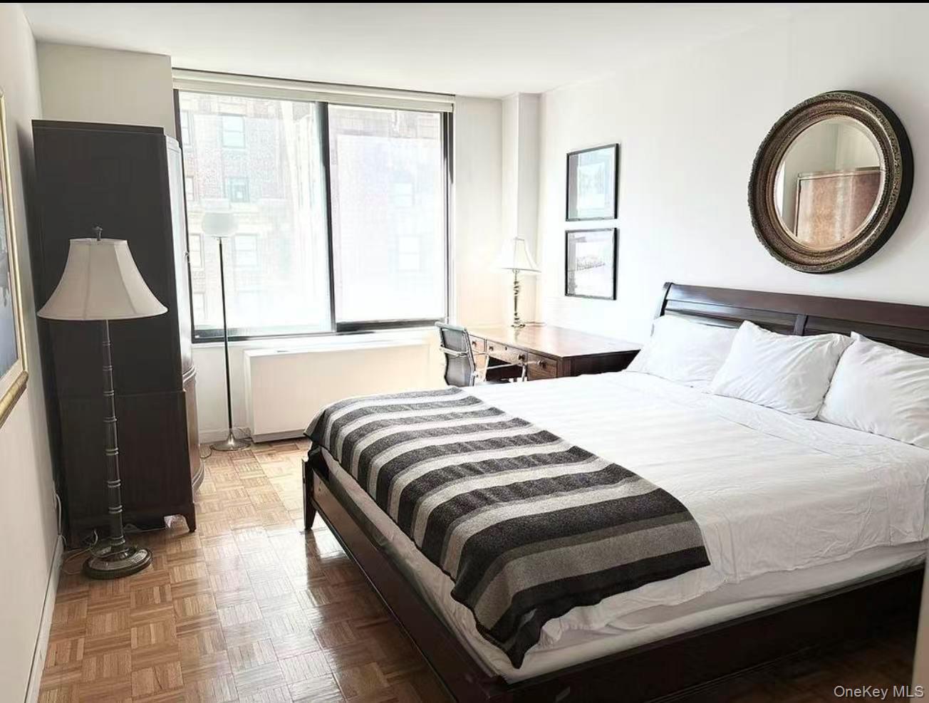 145 East 48th Street, Unit 22C Manhattan, NY 10017 - Photo 5 of 11 a bedroom with a bed and wooden floor