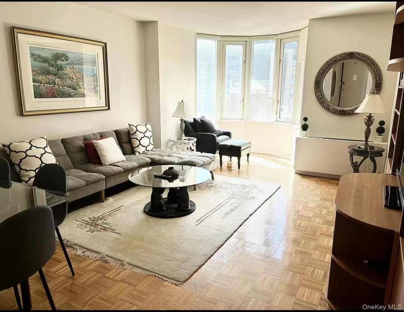 145 East 48th Street, Unit 22C Manhattan, NY 10017 - Photo 7 of 11 a living room with furniture and a large window