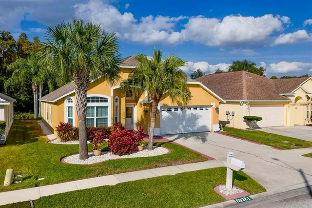 a front view of a house with a yard and potted plants