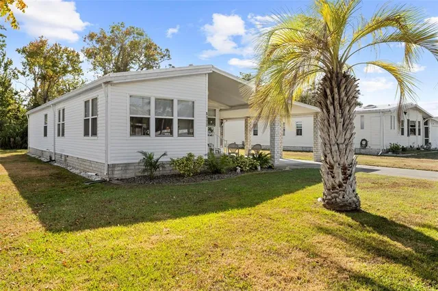 a front view of a house with garden and trees