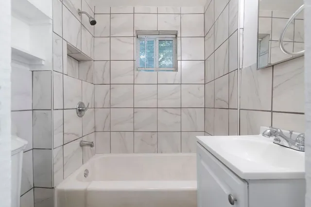 an empty room with wooden floor ceiling fan and windows