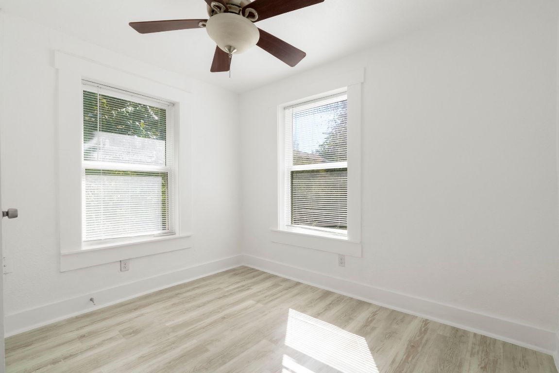 1606 Maple Avenue Austin, TX 78702 - Photo 13 of 15 an empty room with wooden floor ceiling fan and windows